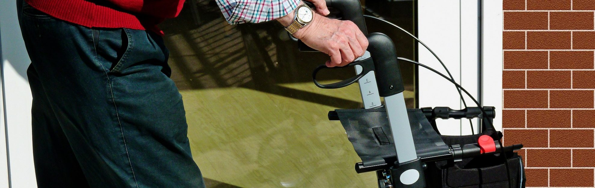 Older man pushing a wheelchair